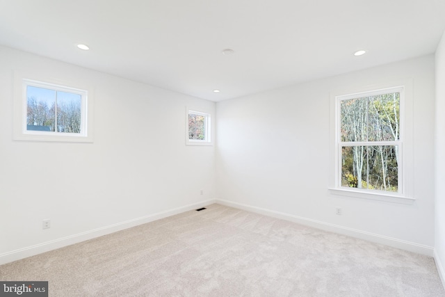 unfurnished room featuring light carpet