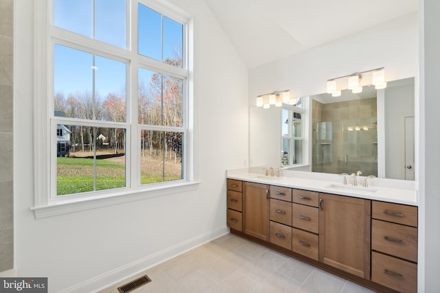 bathroom with tile patterned flooring, vanity, a shower with shower door, and vaulted ceiling