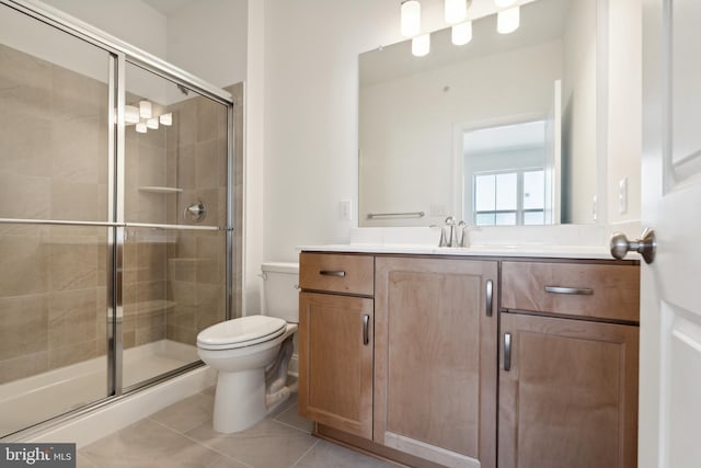 bathroom featuring toilet, vanity, tile patterned floors, and walk in shower