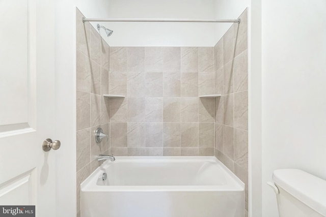 bathroom with toilet and tiled shower / bath