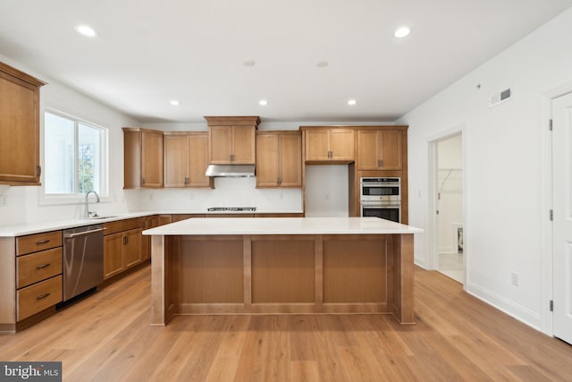 kitchen featuring appliances with stainless steel finishes, a center island, and light hardwood / wood-style flooring