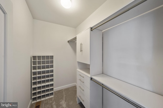 walk in closet featuring dark carpet