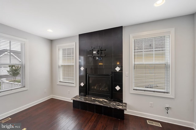 interior details featuring hardwood / wood-style floors and a tile fireplace