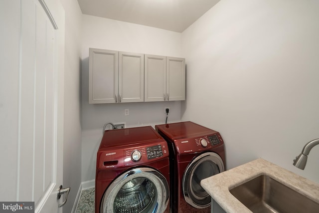 laundry area featuring cabinets, independent washer and dryer, and sink