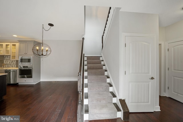 stairway with a notable chandelier and wood-type flooring