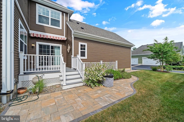 back of house with a garage, an outdoor structure, and a lawn