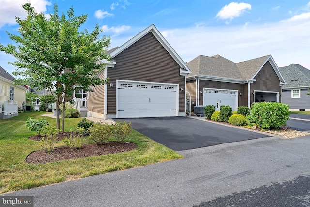 view of front of house with a garage, central air condition unit, and a front lawn