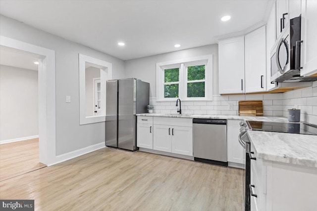 kitchen featuring white cabinets, light stone countertops, sink, and appliances with stainless steel finishes