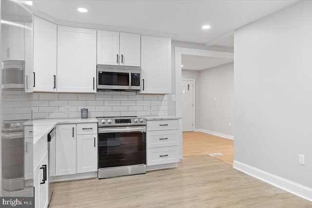 kitchen with light stone countertops, white cabinetry, stainless steel appliances, light hardwood / wood-style flooring, and decorative backsplash