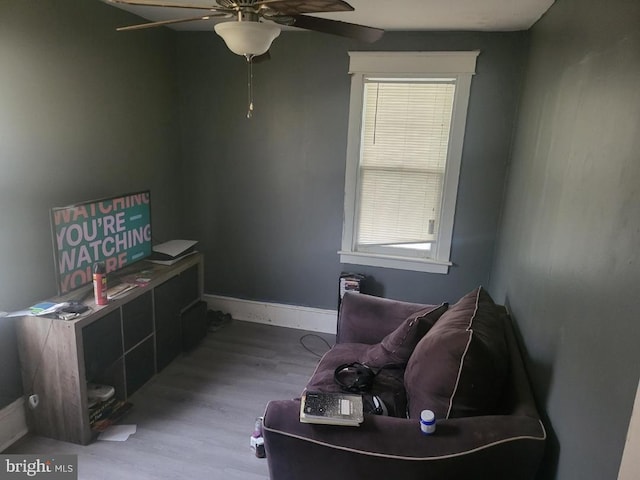 living area featuring hardwood / wood-style flooring and ceiling fan