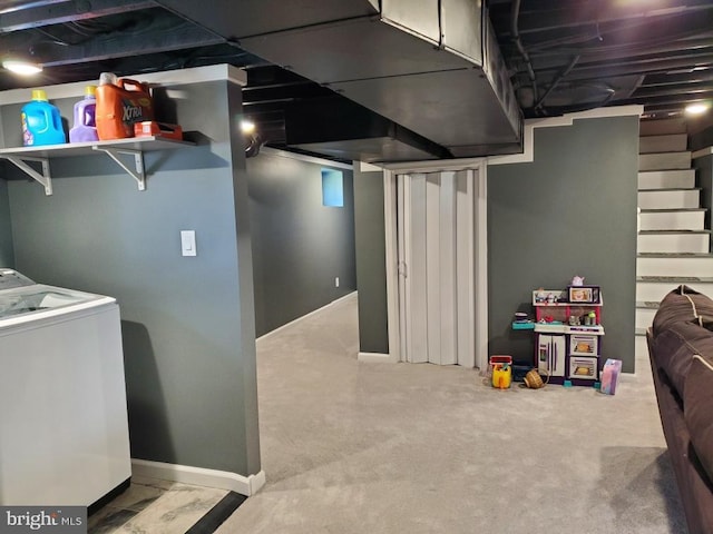 basement featuring light carpet and washer / dryer