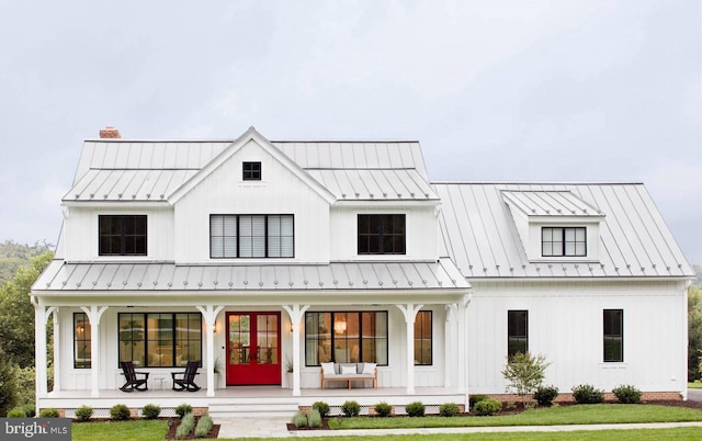 modern farmhouse style home featuring a front lawn, french doors, and a porch