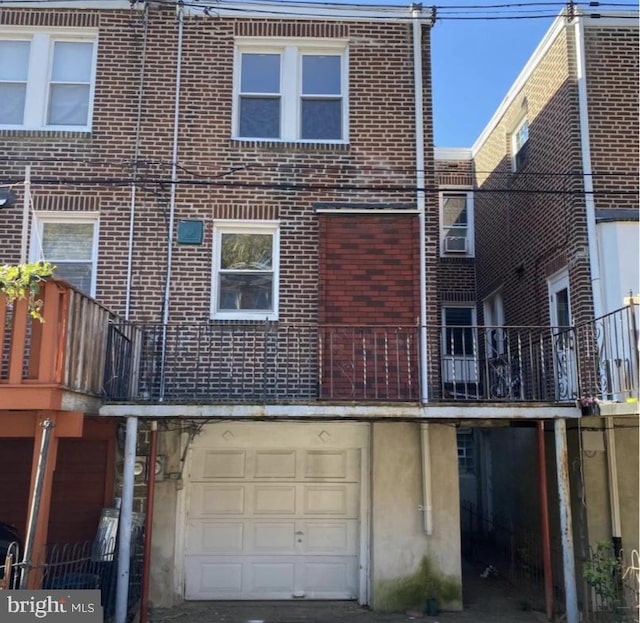 back of property featuring a balcony and a garage