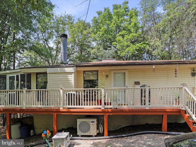 rear view of house with ac unit, a sunroom, and a wooden deck