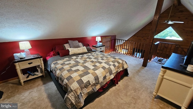 bedroom featuring a textured ceiling, carpet flooring, and vaulted ceiling