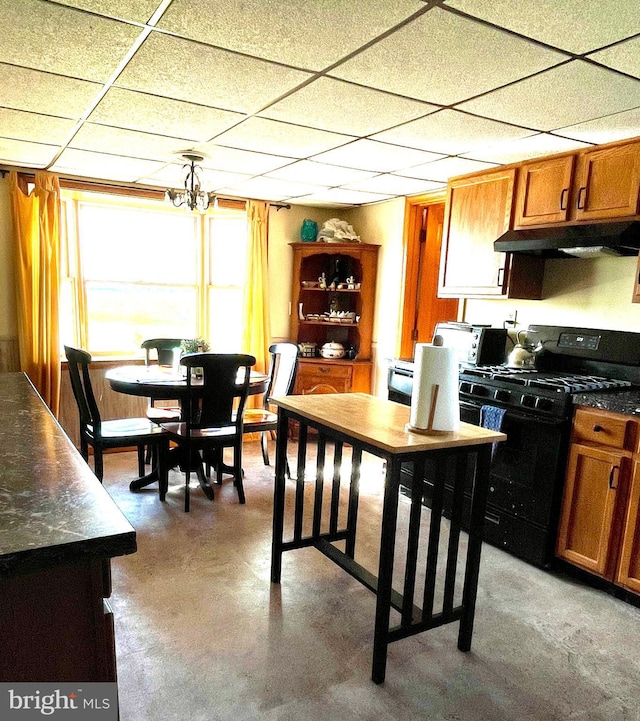 kitchen featuring a drop ceiling, a notable chandelier, and black range with gas cooktop