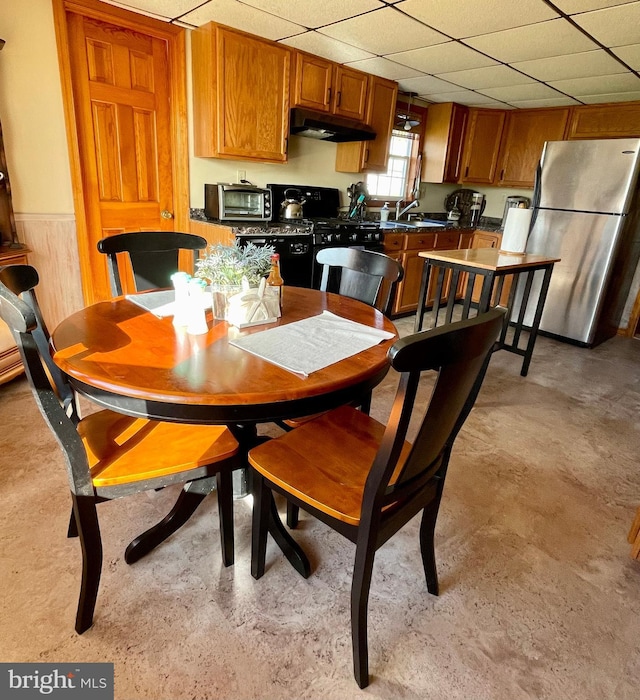 dining area featuring a drop ceiling and sink