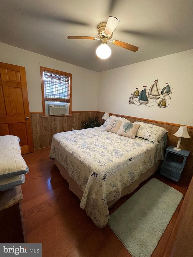 bedroom with ceiling fan, cooling unit, and dark hardwood / wood-style flooring