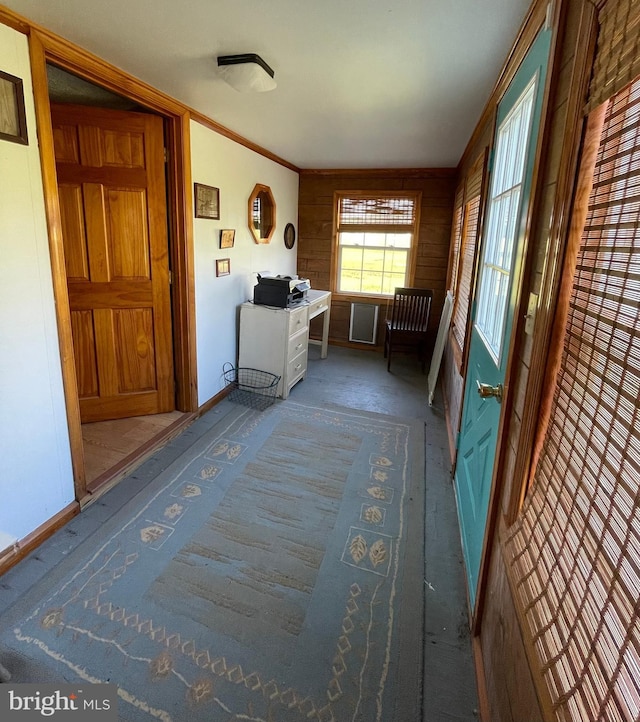 interior space with crown molding, dark carpet, and wooden walls