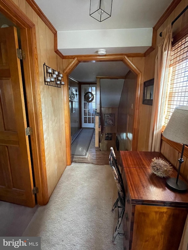 corridor with light colored carpet and wood walls