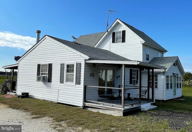 back of property featuring a porch, cooling unit, and a lawn