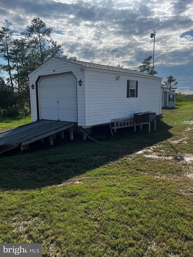 exterior space featuring an outbuilding, a yard, and a garage