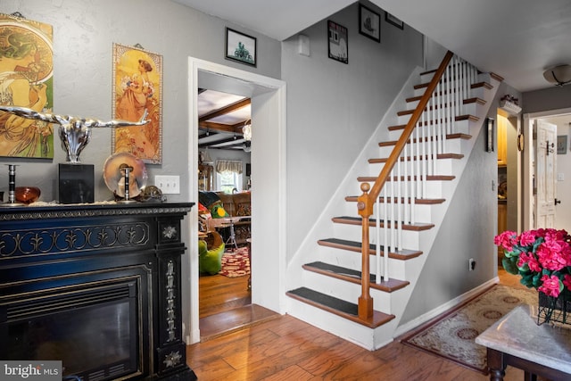 484 Brough Rd, Abbottstown, PA 17301 - stairs featuring wood finished floors, a glass covered fireplace, and beamed ceiling