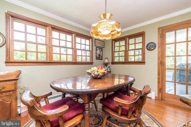 dining area featuring light hardwood / wood-style floors, baseboard heating, and crown molding