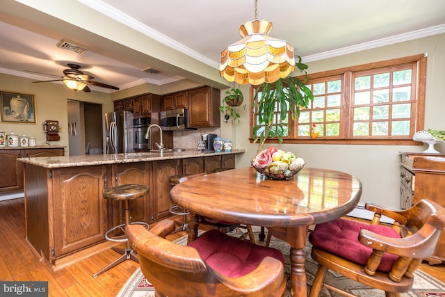 dining room with ceiling fan, light hardwood / wood-style floors, and crown molding