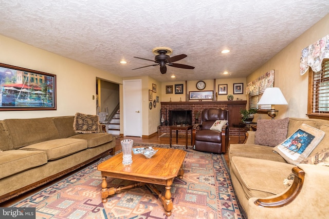 living room with ceiling fan and a textured ceiling