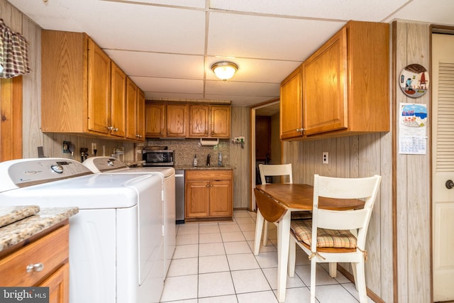 washroom featuring light tile patterned floors, sink, and washing machine and clothes dryer