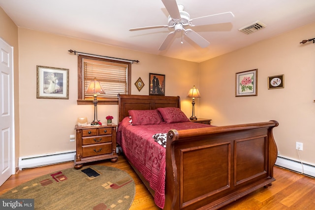 bedroom with ceiling fan, hardwood / wood-style floors, and a baseboard radiator