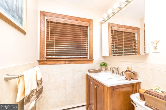 bathroom featuring vanity, tile walls, and toilet