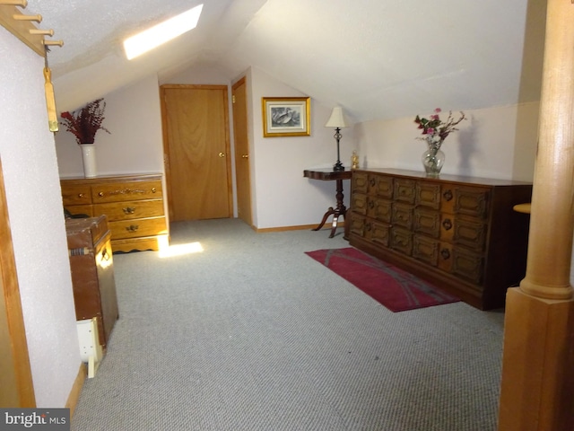 interior space with a textured ceiling, light colored carpet, and vaulted ceiling