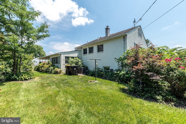 back of house with a lawn and cooling unit