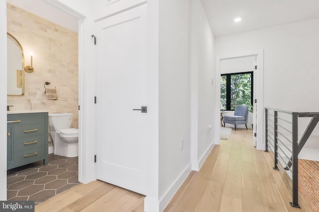 hall featuring tile walls and light wood-type flooring