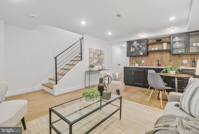 living room with indoor bar and light wood-type flooring