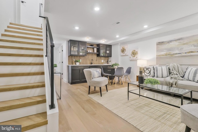 living room featuring wet bar and light wood-type flooring