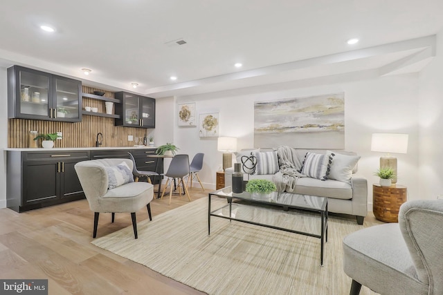 living room featuring bar and light hardwood / wood-style flooring