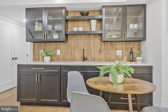 bar with sink and light hardwood / wood-style flooring