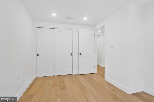 unfurnished bedroom featuring light hardwood / wood-style flooring and a closet