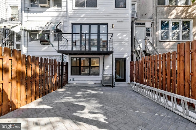 rear view of house with a patio and a balcony