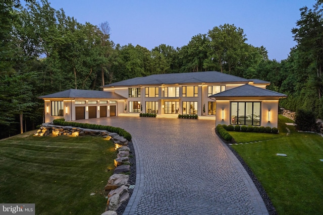 prairie-style house featuring a garage and a lawn