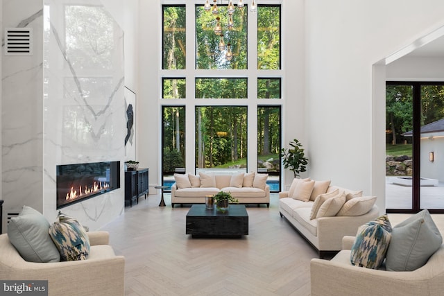 living room featuring a premium fireplace, a high ceiling, and parquet floors