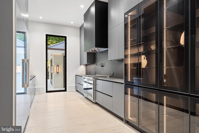 kitchen featuring stainless steel range and wall chimney exhaust hood