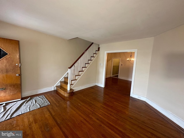 interior space featuring dark wood-type flooring and a notable chandelier