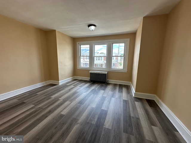 empty room featuring radiator heating unit and dark wood-type flooring