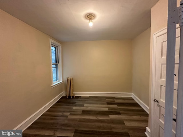 empty room featuring radiator heating unit and dark wood-type flooring