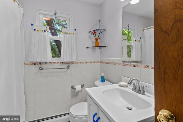 bathroom with a wealth of natural light, a baseboard radiator, tile walls, and toilet