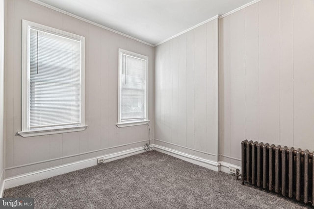 spare room with ornamental molding, carpet floors, and radiator